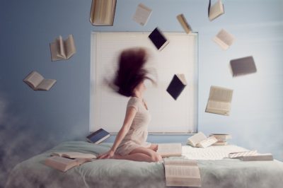 TMS Vorbereitung Bücher: Studienbewerberin mit fliegenden Büchern als Sinnbild für die Auswahl der richtigen TMS-Literatur